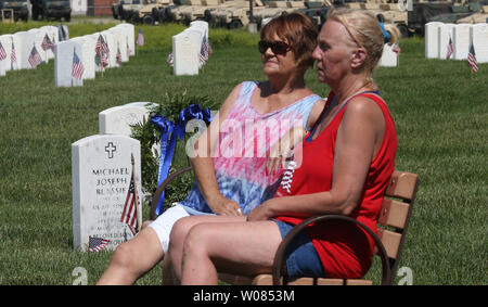 Die Besucher des Memorial Day Service, Zeremonien, die von einer Bank in der Nähe der Grabstätte von Michael Blassie bei Jefferson Barracks National Cemetery in St. Louis am 28. Mai 2018. Blassie, Flugzeug wurde über South Vietnam geschossen und 1972 vermutlich tot. Blassie wurde der Dienst unbekannt Mitglied aus dem Vietnam Krieg begraben am Grab des Unbekannten und war die Ehrenmedaille verliehen. Wenn Familie Mitglieder erfahren, dass seine sterblichen Überreste in der Gruft des Unbekannten begraben werden konnten, Sie Ersuchten das Verteidigungsministerium, um die Site zu öffnen und vorher nicht DNA-Tests durchführen. Im Jahr 1998 hat die Stockfoto