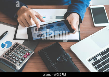 Geschäftsmann mit Text Informationen zum digitalen Tablet finanzielle statistische Daten zu analysieren und die Kosten des Investitionsvorhabens berechnen. Stockfoto