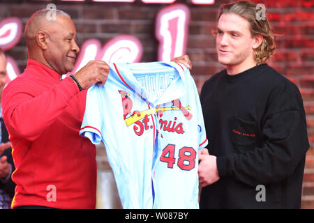 Ehemalige St. Louis Cardinals shortstop und National Baseball Hall of Fame Mitglied Ozzie Smith (L) hilft Kardinäle outfielder Harrison Bader mit seinem neuen Uniform Top bei Enthüllung in St. Louis am 19. November 2018. Die Kardinäle der blauen Uniform, die in den 1980er Jahren an Samstagen getragen Tragen, wenn die Mannschaft auf der Straße ist. Foto von Bill Greenblatt/UPI Stockfoto