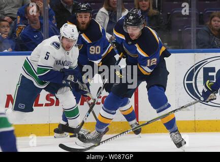 St. Louis Blues Zach Sanford versucht, die airbourn Puck vor Vancouver Canucks Derrick Pouliot in der ersten Periode am Enterprise Center in St. Louis am 9. Dezember 2018 zu steuern. Vancouver besiegt St. Louis 6-1. Foto von Bill Greenblatt/UPI Stockfoto