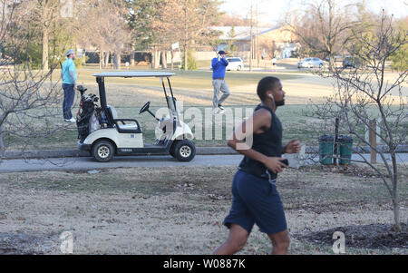 Ein Jogger vorbei Golfspieler auf dem 15 Loch im Forest Park von St. Louis am 3. Februar 2019. Die Temperaturen erreichen 70 Grad am Tag, Läufer, Radfahrer, Wanderer und Golfspieler. Foto von Bill Greenblatt/UPI Stockfoto