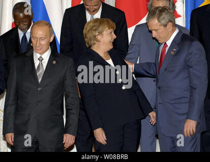 Der russische Präsident Wladimir Putin (L) schaut die Deutsche Bundeskanzlerin Angela Merkel lächelt, um US-Präsident George W. Bush (R) während der Staats- und Regierungschefs der G8-Gruppe Foto im Anschluss an die letzte Sitzung des G8-Gipfels in Sankt Petersburg, Russland am 17. Juli 2006 Von links in der oberen Reihe sind der südafrikanische Präsident Thabo Mbeki, der mexikanische Präsident Vicente Fox, der japanische Ministerpräsident Junichiro Koizumi und der kanadische Premierminister Stephen Harper. (UPI Foto/Dima Volgin) Stockfoto