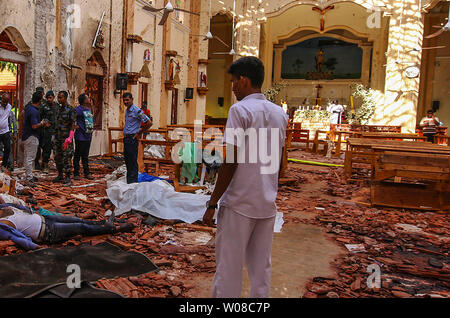 Sri Lankan Soldaten sehen Sie auf der Innenseite des St. Sebastian Kirche in Negombo am 21 April, 2019, nach einem Bombenanschlag während der ostergottesdienst getötet, dass Sonnenanbeter. Eine Serie von acht verheerenden Bombenanschlägen durch High-end Hotels und Kirchen holding Ostergottesdienste in Sri Lanka zerrissen am 21. April fast 200 Menschen getötet, darunter Dutzende von Ausländern. Foto von Perera Pattin/UPI Stockfoto