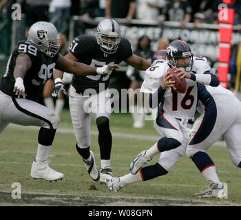 Denver Broncos QB Jake Plummer (16) kriecht für sechs Yards als Oakland Raiders Warren Sapp (99) und Lance Johnstone (51) verfolgen im dritten Quartal bei McAfee Coliseum in Oakland, Kalifornien am 12. November 2006. Die Broncos besiegt die Räuber 17-13. (UPI Foto/Terry Schmitt) Stockfoto