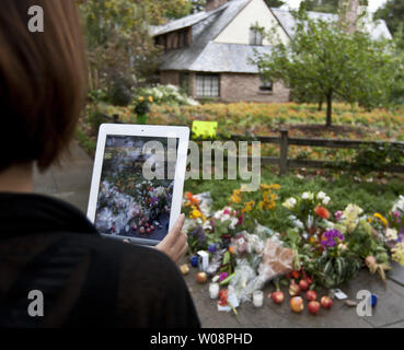 Eine Frau verwendet ihr iPad zu fotografieren einer improvisierten Schrein vor Steve Jobs in Palo Alto, Kalifornien, am 6. Oktober 2011. Gönner vom Haus gestoppt, Blumen, Kerzen und die Äpfel im Tribut an Apple Co zu verlassen - Gründer Jobs, der starb, 10/5 im Alter von 56 Jahren. UPI/Terry Schmitt Stockfoto