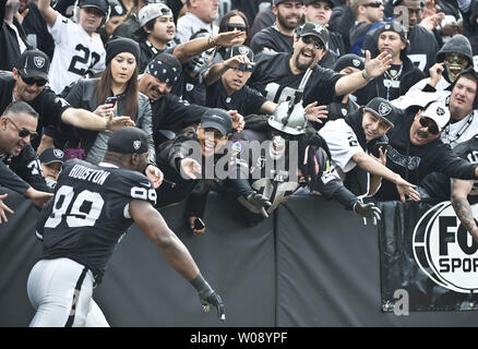 Oakland Raiders Lamarr Houston (99) grüsst Fans in das Schwarze Loch vor dem Spielen die Philadelphia Eagles an O. co Coliseum in Oakland, Kalifornien am 3. November 2013. UPI/Terry Schmitt Stockfoto