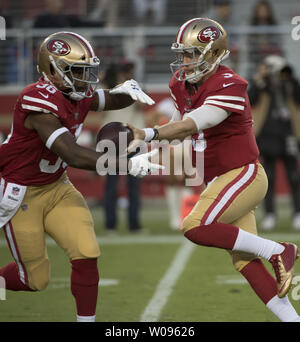 San Francisco 49ers QB C.J. Beathard (R) Hände weg zu RB Alfred Morris im ersten Quartal gegen die Los Angeles Ladegeräten an Levi's Stadion in Santa Clara, Kalifornien am Donnerstag, 30. August 2018. Foto von Terry Schmitt/UPI Stockfoto