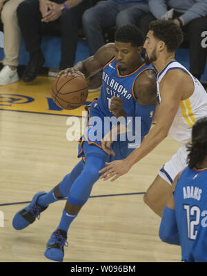 Oklahoma City Thunder, Paul George (L) versucht, auf Golden State Warriors guard Klay Thompson im ersten Quartal in der Oracle Arena in Oakland, Kalifornien am Oktober 16, 2018 zu fahren. Die Krieger besiegt den Donner 108-100. Foto von Terry Schmitt/UPI Stockfoto