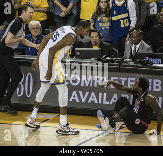 Golden State Warriors forward Kevin Durant (35) steht über LA Clippers guard Patrick Beverley (21) in der zweiten Hälfte der NBA Endspiele in der Oracle Arena in Oakland, Kalifornien am 13. April 2019. Beide Spieler wurden ausgestoßen. Die Krieger besiegt die Scherer 121-104. Foto von Terry Schmitt/UPI Stockfoto