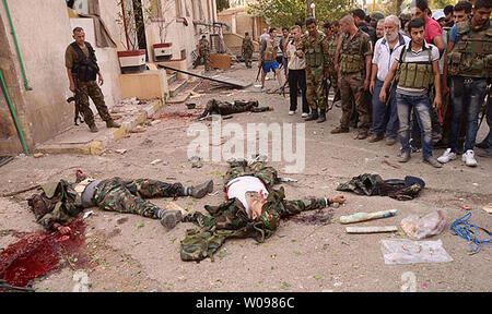 In diesem Foto, das durch die syrische offizielle Nachrichtenagentur SANA freigegeben, die Syrische Armee Soldaten stehen neben offensichtlichen rebel Bomber in militärischen Gang gekleidet, nachdem sie in der Nähe der Szene, wo mehrere Bomben Explosionen im Zentrum von Aleppo, Syrien am 3. Oktober 2012 schlug erschossen wurden. Die offensichtlichen Selbstmord Auto blasts im von der Regierung kontrollierten Gebiet kam innerhalb von Minuten von einander und tötete mindestens 40 Menschen. Aleppo ist Syriens zweitgrößte Stadt und ist im Wesentlichen in der Hälfte mit den Rebellen die Kontrolle der östlichen Teil und die Regierung die Kontrolle der westlichen Teil aufgeteilt. UPI Stockfoto