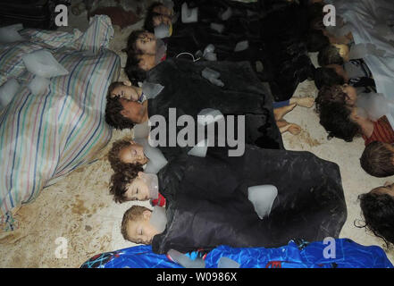 Einrichtungen der Kinder in Leichentücher gewickelt liegen in eine temporäre Leichenhalle im östlichen Ghuta, am Stadtrand von Damaskus in Syrien am 21. August 2013. Rebellen behaupten, sie in ein giftiges Gas Angriff durch regierungsnahe Kräfte und die syrische Regierung getötet wurden, hat die Ansprüche verweigert. Die UNO untersucht. UPI/Diaa El Din Stockfoto