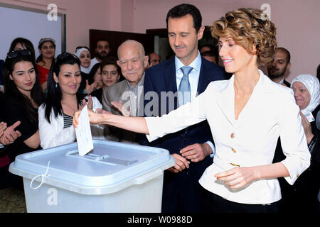 In diesem Foto von Syriens nationale Nachrichtenagentur veröffentlicht, der syrische Präsident Baschar al-Assad und der syrischen First Lady Asma Assad Stimmen bei der Präsidentschaftswahl des Landes in einem Wahllokal in Maliki, einer Wohngegend im Zentrum der Hauptstadt Damaskus, Syrien, am 3. Juni 2014, Syrer aufgereiht vor wahllokalen in den von der Regierung kontrollierten Gebieten um das Land zu Stimme Dienstag in der Präsidentenwahl wird allgemein erwartet, dass Assad zu gewinnen, aber die Opposition im Exil hat die Zugeschlagen als "Farce". UPI Stockfoto