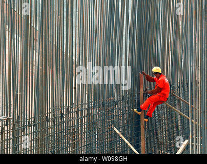 Ein Bauarbeiter Bindungen Stahl Betonstahl zusammen an einem Entwicklungsprojekt in Shenzhen, einer größeren Stadt in der südchinesischen Provinz Guangdong am 22. Oktober 2013. China hat eine Smart City Programm landesweite asa Teil seiner Bemühungen um die Möglichkeiten, eine neue Art von Urbanisierung zu fördern erforschen eingeleitet. UPI/Stephen Rasierer Stockfoto