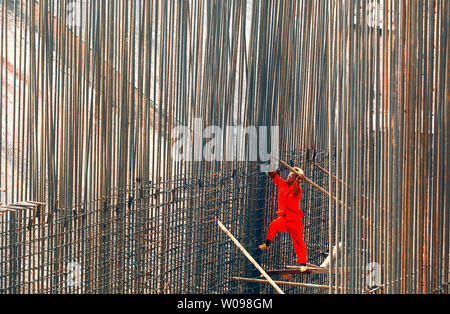 Ein Bauarbeiter Bindungen Stahl Betonstahl zusammen an einem Entwicklungsprojekt in Shenzhen, einer größeren Stadt in der südchinesischen Provinz Guangdong am 22. Oktober 2013. China hat eine Smart City Programm landesweite asa Teil seiner Bemühungen um die Möglichkeiten, eine neue Art von Urbanisierung zu fördern erforschen eingeleitet. UPI/Stephen Rasierer Stockfoto