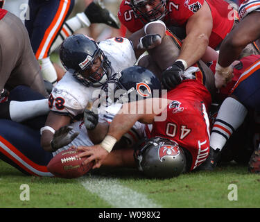 Tampa Bay Buccaneers fullback Mike Alstott (40) is tripped up by  Indianapolis Colts' Raheem Brock (79), while Colts' Montae Reagor (90)  chases during the first quarter Monday night Oct. 6, 2003 in