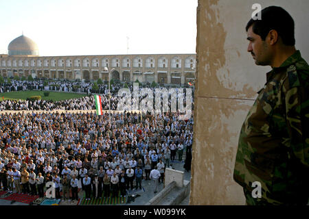 Mitglied der Basiji Milizen steht auf einem Dach wie die Iraner beten an naghshe Jahan Sq in Isfahan liegt etwa 340 KM südlich von Teheran, Iran während des Eid-al-Fitr Festival am September 10,2010. Das Festival markiert das Ende des Heiligen muslimischen Fastenmonats Ramadan. UPI/Maryam Rahmanian Stockfoto