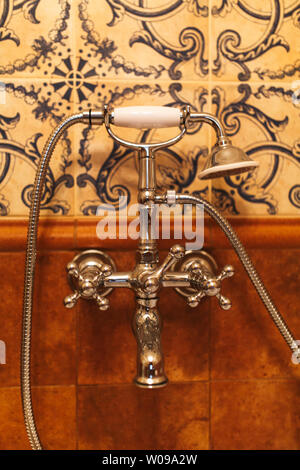 Retro Kran und Dusche im Badezimmer. Im Badezimmer ist eine Retro Stil mit Furnier Armaturen und einem marmornen Oberfläche Stockfoto