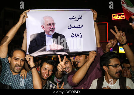 Iraner halten Sie ein Bild der iranische Außenminister Javad Zarif beim Feiern auf den Straßen von Teheran nach der Bekanntgabe des Irans nukleare Historische befassen sich mit der Welt in Wien am 14. Juli 2015. Foto von Saba Taherian/UPI Stockfoto