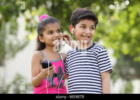 Zwei Kinder, einen MP3-Player anhören Stockfoto