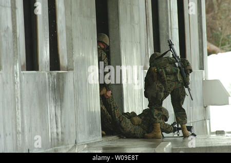 Soldaten der US-Marines tragen eine "verletzte" Kameraden in das Gebäude während der Stadt kämpfen Training mit der japanischen Boden Verteidigung-kraft in der Aibano Weiterbildung, Shigaga Präfektur, Japan, am 23. Februar 2006. (UPI Foto/keizo Mori) Stockfoto