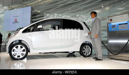 Mitsubishi Motors Präsident Osamu Masuko steht neben der "i-MiEV" wird angezeigt, während ein Vorstellen an der Mitsubishi Motors Company Hauptsitz in Tokio Juni 5, 2009. Die vollelektrische Auto kann an eine Standard 110- oder 220-V-Steckdose im Inland. (UPI Foto/Keizo Mori) Stockfoto