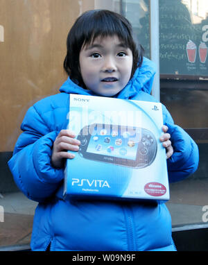 Ein Kunde stellt mit dem tragbaren video game Player" PlayStation (PS Vita)' an der 'TSUTAYA ' Shibuya in Tokio, Japan, am 17. Dezember 2011. PS Vita wird in Europa und den USA am 22. Februar 2012 veröffentlicht werden. UPI/Keizo Mori Stockfoto