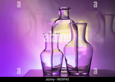 Die Umrisse der zwei Glas Vasen und Flaschen auf einem leuchtend violetten und gelben Hintergrund, horizontales Layout. Stockfoto