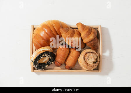 Mandel Krapfen Brötchen, Croissant, Crab Cake, weiche Rollen Kuchen mit Wurst auf Holzplatte, selektiven Fokus Stockfoto