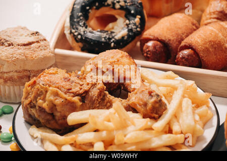 Fast Food und ungesundes Essen Konzept - in der Nähe von Fast-Food-Snacks und Cola trinken am weißen Tisch Stockfoto