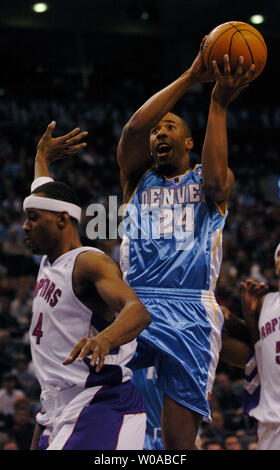Andre Denver Nuggets" Miller nimmt einen Schuß am Korb als Toronto Raptors' Morris Peterson eilt zurück auf Verteidigung im ersten Quartal Aktion in der Air Canada Mitte Dezember 10, in Toronto, Kanada 2004 zu erhalten. Miller zählte 18 Punkte auf die Nacht als die Nuggets auf ging die Raptors 101-87 zu besiegen. (UPI Foto/Christine Kauen) Stockfoto
