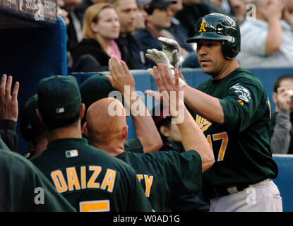 Oakland Athletics' Adam Melhuse erhält Glückwünsche von Mannschaftskameraden im Dugout, nachdem er auf seiner 2-run Homer aus Toronto Blue Jays, der Pitcher Gustavo Chacin im zweiten Inning in der Rogers Centre in Toronto, Kanada, am 10. Mai 2006. Die Eichelhäher ging auf die Leichtathletik 9-7 zu besiegen. (UPI Foto/Christine Kauen) Stockfoto