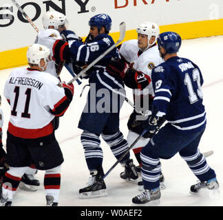 Toronto Maple Leafs' Ben Ondrus und Ottawa Senators' Wade Röten kommen zu den Schlägen als Senatoren Kapitän Daniel Alfredsson und treibt Kapitän Mats Sundin bis Skate während der ersten Periode im Air Canada Centre in Toronto, Kanada, am 24. Oktober 2006 zu intervenieren. Die Senatoren besiegt die Blätter 6-2. (UPI Foto/Christine Kauen) Stockfoto