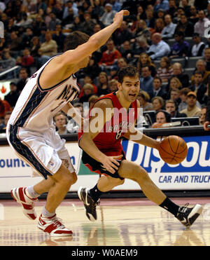 Toronto Raptors' Jose Calderon von Spanien treibt die Kugel durch New Jersey Nets' Bostjan Nachbar im zweiten Quartal im Air Canada Centre in Toronto, Kanada, am 14. Februar 2007. Calderon zählte 16 Punkte in der Raptors' 120-109 Gewinn über die Netze. (UPI Foto/Christine Kauen) Stockfoto