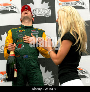 Ein Moderator begrüßt als australische Fahrer Leistung (L) mit Emotion überwunden wird, während er seine ersten Platzende feiert in der Champ Car Serie Rennen auf dem Steelback Grand Prix von Toronto an der Ausstellung in Toronto, Kanada, am 8. Juli 2007. (UPI Foto/Christine Kauen) Stockfoto