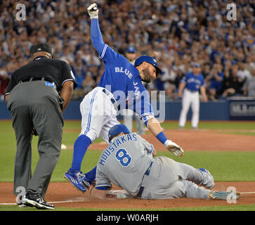 Kansas City Royals Third Baseman Mike Moustakas (8) Variablen aus Toronto Blue Jays Kevin Säule an der dritten Base während des achten Inning in der alcs Spiel 5 in der Rogers Centre in Toronto, Kanada, am 21. Oktober 2015. Säule hit zählte Teamkollege Troy Tulowitzki auf dem Spiel. Kansas City hält eine Reihe 3-1 Leitung über Toronto. Foto von Kevin Dietsch/UPI Stockfoto