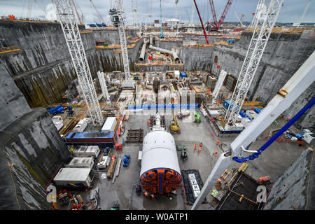 Embargo auf 0001 Freitag, den 28. Juni eine massive Tunnelbohrmaschine im Vordergrund und riesigen kühlwasserleitungen sitzen auf dem tief graben Aushub Kühlkörper in Hinkley Point C, wo Großbritannien, das die größten jemals gießen Beton, rund 9'000 m3, die während der Bau der umgibt, für den Kernreaktor im Kraftwerk in der Nähe von Bridgwater, Somerset. Das gießen Beat das bisher größte, die beim Bau der Shard in London war. Stockfoto