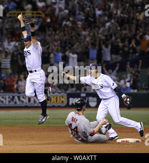 Tampa Bay Rays zweite Basisspieler Akinori Iwamura (C) und shortstop Jason Bartlett feiern wie Boston Red Sox outfielder Jason Bay in zweiten Folien wie die Strahlen die Niederlage der Red Sox 3-1 der American League Meisterschaft an der Tropicana Field in St. Petersburg, Florida am 19. Oktober 2008 zu gewinnen. Die Strahlen werden die Philadelphia Phillies in Ihren ersten World Series aussehen. (UPI Foto/Kevin Dietsch) Stockfoto