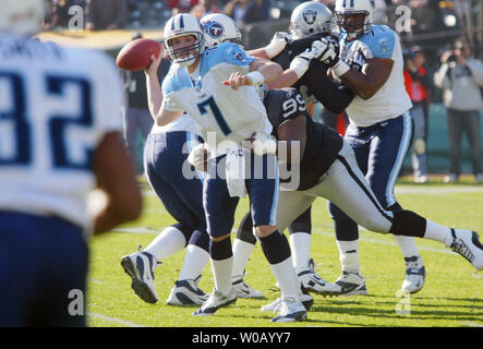 Tennessee Titans QB Billy Volek (7) sieht, zu Antowain Smith (32), wie er durch die Räuber Warren Sapp (99) in Oakland, CA, ist am 19. Dezember 2004. Die Räuber besiegt die Titanen 40-35. (UPI Foto/Bruce Gordon) Stockfoto