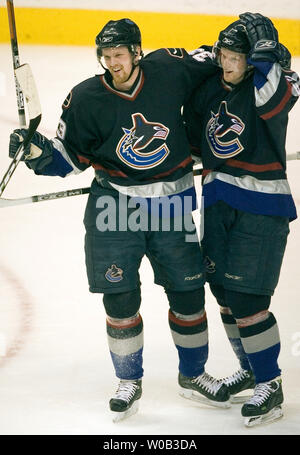 Vancouver Canucks Henrik Sedin (L) feiert zählen das erste Ziel des Spiels kurz auf einem übergeben Unterstützung von Bruder Daniel Sedin(R) gegen die Dallas Stars in der zweiten Periode von einem NHL Spiel bei Vancouver, GM Place, 11. März 2006. Dallas über Vancouver 2-1. (UPI Foto/Heinz Ruckemann) Stockfoto