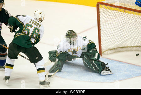 Vancouver Canucks Henrik Sedin (L) Kerben das erste Ziel des Spiels, shorthanded auf einer Vorlage von Bruder Daniel, der Puck hinter dem Besichtigen von von Dallas Stars Verteidiger Sergei Zhubov und goalie Marty Turco in der zweiten Periode von einem NHL Spiel bei Vancouver, GM Place, 11. März 2006. Dallas über Vancouver 2-1. (UPI Foto/Heinz Ruckemann) Stockfoto