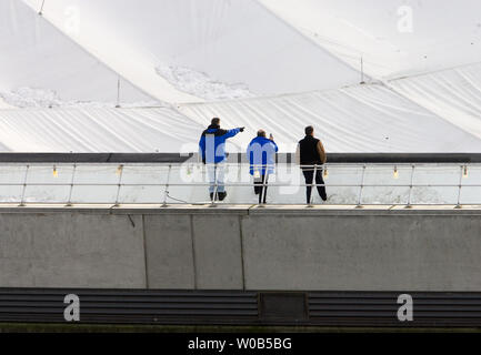 Schneeberge Stick auf den Außenrand des deflationiert Dach BC Place Stadium durch Arbeitnehmer Januar 6, 2007 in Vancouver, British Columbia kontrolliert wird. Berichte zirkulierenden 8. Januar 2007, schlagen die großen Riss zwingen die Mitarbeiter der druckbeaufschlagten Dome, ursprünglich der starken Winde zum 5. Januar 2007, die durch das Personal verursacht wurden die Erhöhung der Kuppel der Druck über dem normalen freien Schnee auf den Teflon Oberfläche eher als das Drehen auf der Kuppel Heizsystem zu schütteln zugeschrieben zu entleeren, ein kostspieliger. (UPI-Datei Foto/Heinz Ruckemann) Stockfoto