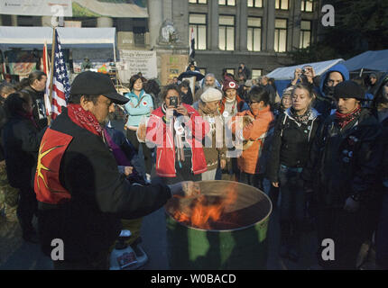 Erste Nationen Teilnehmer des 'besetzen Vancouver Protest relight ein heiliges zeremonielles Feuer in einem Faß an der kunst-Galerie Zeltstadt in der Innenstadt von Vancouver, British Columbia Ende November 8, 2011, nach der heutigen Stadt Vancouver Versuch zur Erlangung einer einstweiligen Zeltstadt zu entfernen geht zurück zu Gericht morgen. Polizei und Feuerwehr met Widerstand von Demonstranten in der vergangenen Nacht, da sie ein ähnliches Feuer übergossen und zitierte Sicherheitsbedenken. UPI/Heinz Ruckemann Stockfoto