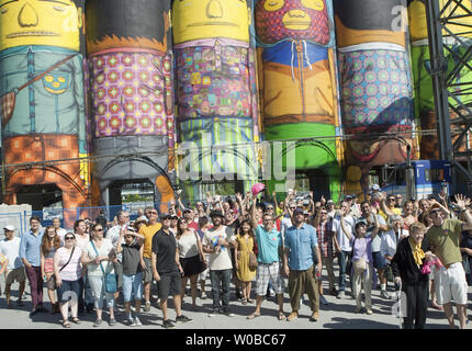 Durch Vancouver Biennale gesponsert, brasilianischer Künstler Gustavo und Otavio Pandolfo bekannt als OSGEMEOS (portugiesisch für "die Zwillinge"), kommen die Biennale Gründer Barry Mowatt (Rosa hard hat), wie sie die Öffentlichkeit auf die offizielle Vorstellung des "Riesen" die Zwillinge größten öffentlichen Wandbild überhaupt, 360 Grad, 23 U-Bahn hohe öffentliche Kunst Projekt in sechs Ozean Konzerte Silos auf Granville Island in Vancouver, British Columbia, September 7, 2014 einladen. UPI/Heinz Ruckemann Stockfoto