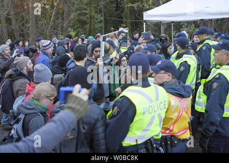 Die Demonstranten halten einen Spiegel vor die RCMP Polizei Linie als über 400 Menschen stellte sich heraus, Umfrage Bohren auf Burnaby Mountain von US-amerikanischen Unternehmen Kinder Morgan für Ihre vorgeschlagene zweite Pipeline von der Alberta tar sands nach Vancouver, British Columbia am 23. November 2014 zu protestieren. Über 60 Menschen wurden seit Donnerstag, wenn rcmp Polizisten begannen Durchsetzung einer v. Chr. Oberste Gerichtshof einstweilige Verfügung gegen Kinder Morgan Demonstranten festgenommen. UPI/Heinz Ruckemann Stockfoto