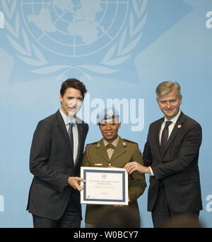 Kanadas Premierminister Justin Trudeau (L) und Untergeneralsekretär für Friedenserhaltende Operationen Jean-Pierre Lacroix vorhanden South African National Defence Force Major Seitebatso Pearl Block mit den Vereinten Nationen militärische Geschlecht Fürsprecher des Jahres bei der Eröffnung der Plenarsitzung während der 2017 UN-Peacekeeping Verteidigung Ministerkonferenz in Vancouver, British Columbia, 15. November 2017. UPI/Heinz Ruckemann Stockfoto