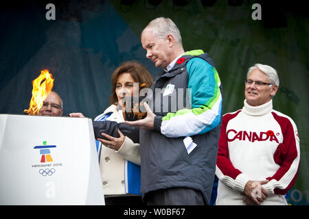 British Columbia (BC) Premier Gordon Campbell Uhren als VANOC CEO John furlong hilft den letzten Witwe Darlene Poole Licht der 1.2-Meter gemeinschaftlichen Feier Kessel mit der olympischen Flamme am BC Gesetzgebung, wo der erste Fackelträger der 2010 Winter-olympischen Fackellauf in Victoria, BC, 30. Oktober 2009 beginnt. UPI/Phillip Kinn Stockfoto