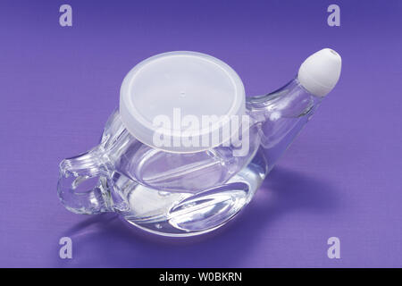 Neti Pot mit Soft Comfort Tipp isoliert auf lila Hintergrund. Sinus waschen. Nasale Bewässerung. Stockfoto