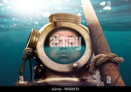 Porträt des Menschen in alten Taucheranzug und Helm unter Wasser. Lustige Taucher in retro Ausstattung mit Wasser in seinen Helm. Stockfoto
