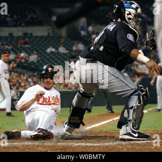 Die Baltimore Orioles Brandon Fahey (12) Folien sicher in Home im dritten Inning auf Single von Melvin Mora gegen Bengie Molina (1) von den Toronto Blue Jays auf Orioles Park at Camden Yards, Baltimore, MD, am 8. Juni 2006. (UPI Foto/Mark Goldman) Stockfoto