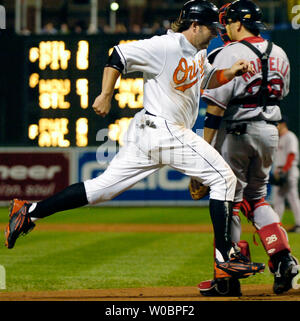 Die Baltimore Orioles Kevin Millar kommt in die Kerbe im zweiten Inning auf einer werfenden Störung durch die Boston Red Sox catcher Doug Mirabelli (R), die am 13. September versucht Millar aus an der dritten Base, 2006 an der Orioles Park at Camden Yards, Baltimore, Maryland. Die Orioles besiegten die Red Sox 4-0. (UPI Foto/Mark Goldman) Stockfoto